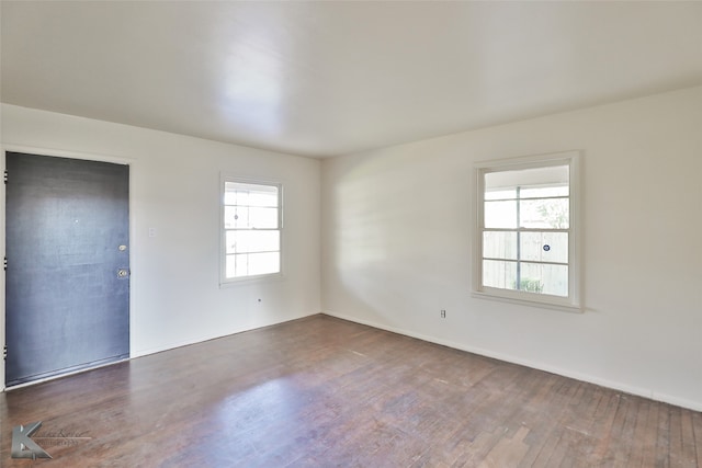 empty room featuring dark hardwood / wood-style flooring and a wealth of natural light