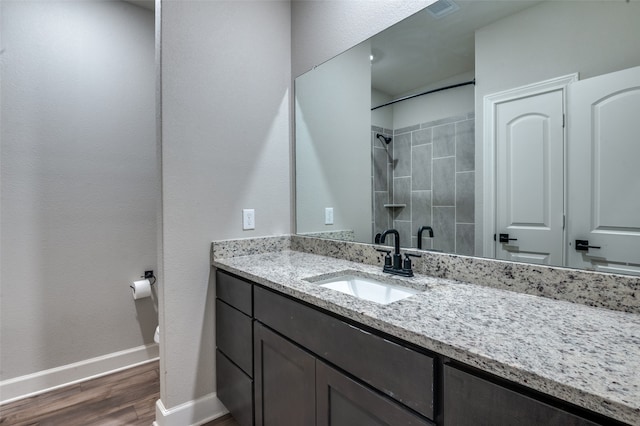 bathroom with toilet, hardwood / wood-style floors, vanity, and walk in shower