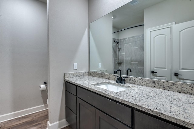 7609 Duck Bay Rd, Fort Worth, TX 76120 - bathroom with baseboards, vanity, wood finished floors, a tile shower, and toilet