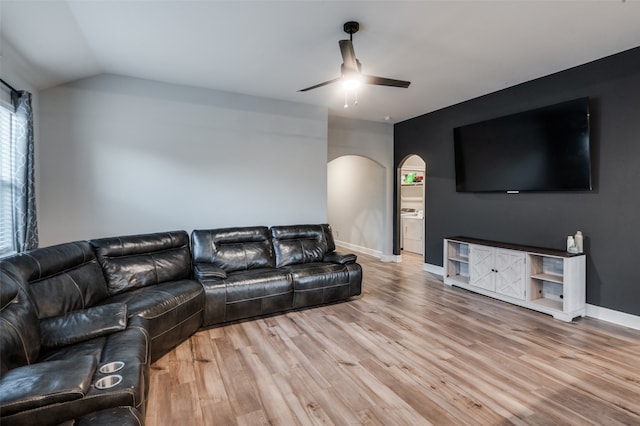 living room with ceiling fan, vaulted ceiling, and light wood-type flooring