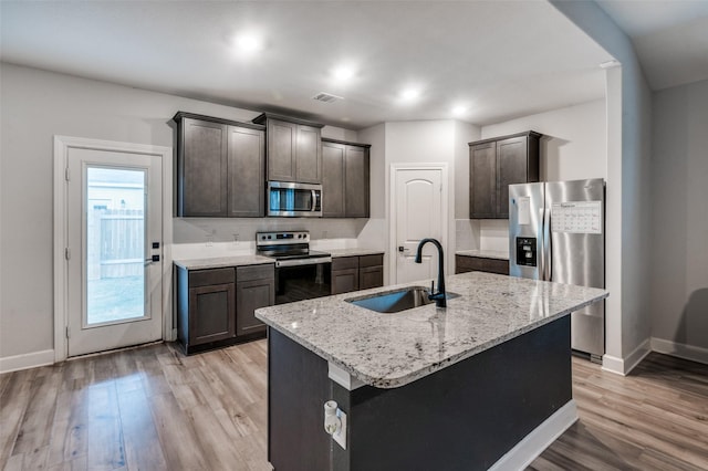 7609 Duck Bay Rd, Fort Worth, TX 76120 - kitchen featuring stainless steel appliances, a sink, baseboards, light wood-style floors, and dark brown cabinets