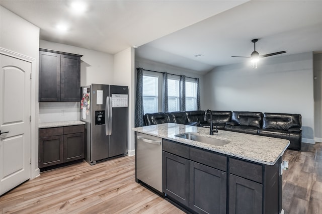 kitchen with sink, ceiling fan, light wood-type flooring, an island with sink, and stainless steel appliances