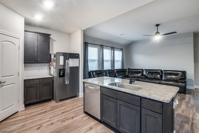 7609 Duck Bay Rd, Fort Worth, TX 76120 - kitchen featuring appliances with stainless steel finishes, a sink, light wood-style flooring, open floor plan, and light stone counters