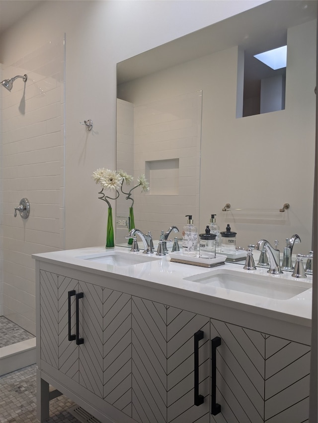 bathroom featuring tiled shower and sink