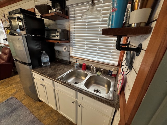 kitchen featuring decorative backsplash, stainless steel fridge, and sink