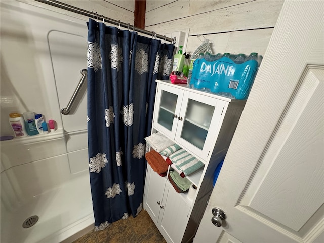 bathroom featuring walk in shower and wooden walls