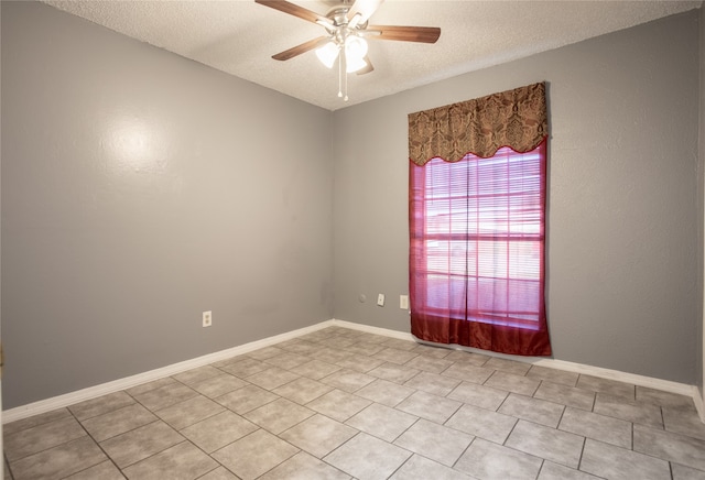 tiled spare room with a textured ceiling and ceiling fan