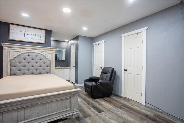 bedroom with ensuite bathroom and dark wood-type flooring