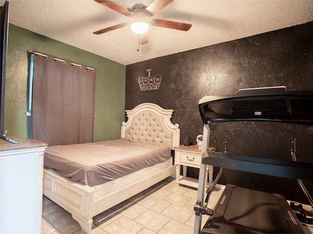 bedroom with ceiling fan, light tile patterned floors, and a textured ceiling