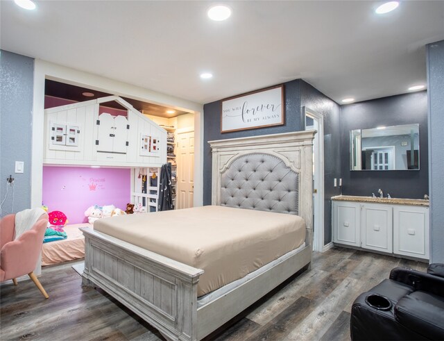 bedroom with dark hardwood / wood-style floors, a closet, and sink