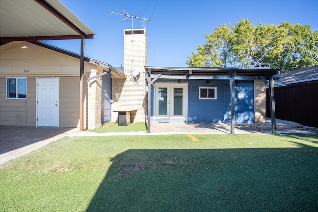 rear view of house featuring a yard, a patio area, and french doors