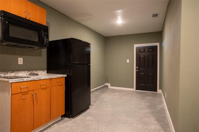 kitchen featuring light carpet and black appliances