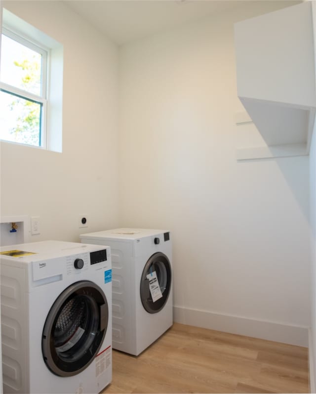 washroom featuring washer and clothes dryer and light hardwood / wood-style floors