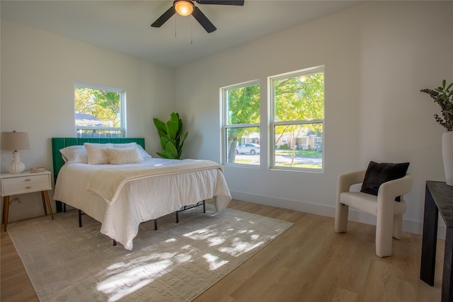 bedroom with light hardwood / wood-style flooring, multiple windows, and ceiling fan