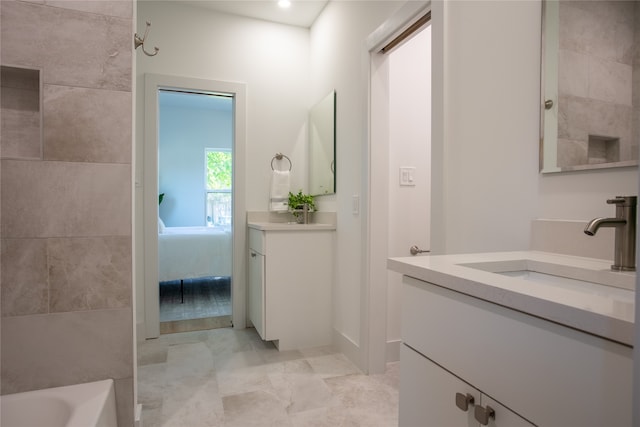 bathroom with vanity and a washtub