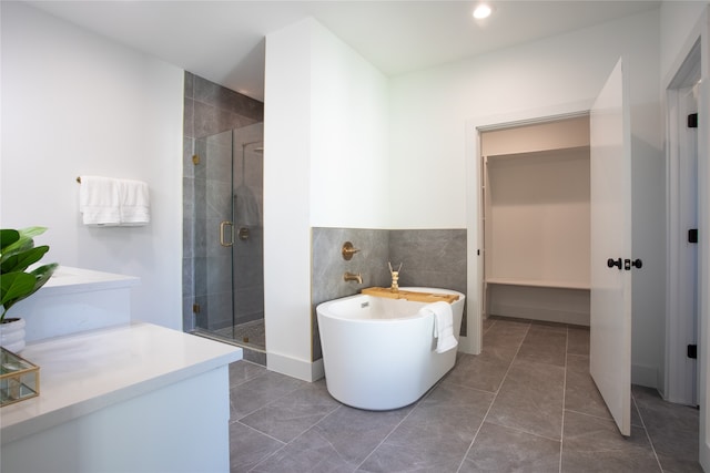 bathroom featuring tile patterned floors, tile walls, and independent shower and bath