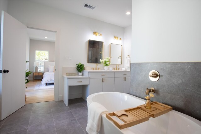 bathroom with vanity, a tub to relax in, and tile patterned floors