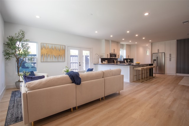 living room with french doors and light wood-type flooring