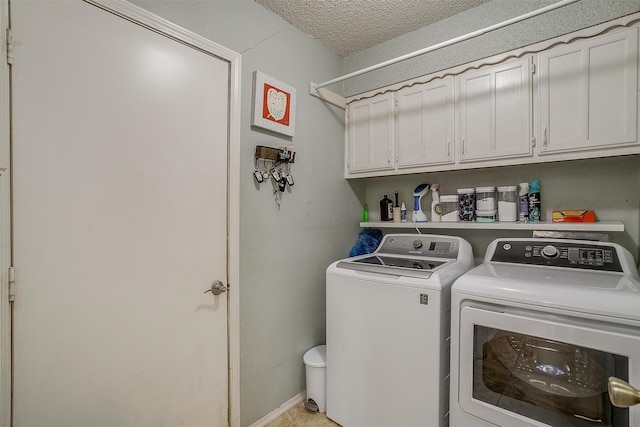 washroom with washer and clothes dryer, cabinets, and a textured ceiling