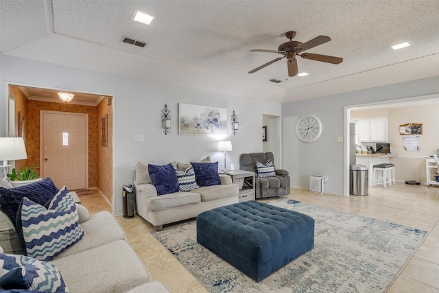 tiled living room with ceiling fan and a textured ceiling