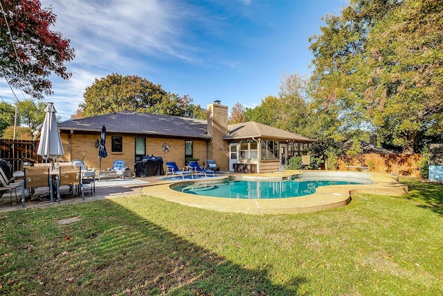 view of pool with a patio and a lawn