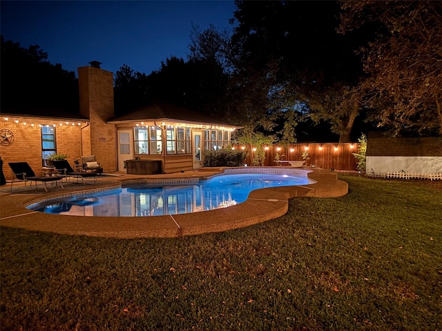 pool at night featuring a patio area and a jacuzzi