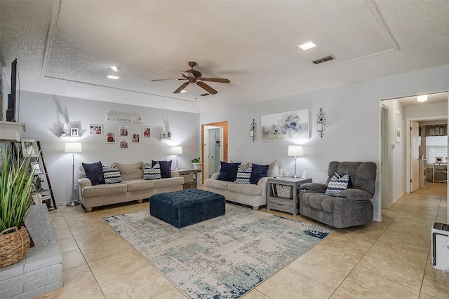 tiled living room with ceiling fan and a textured ceiling