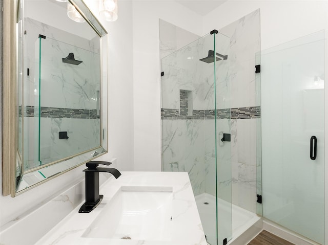 bathroom featuring vanity, wood-type flooring, and walk in shower