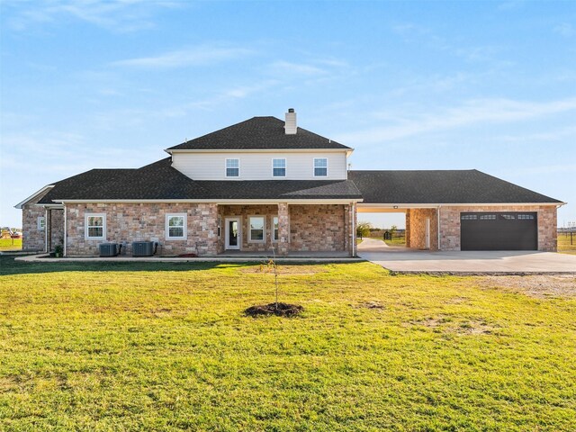 view of front of property featuring cooling unit, a garage, and a front lawn