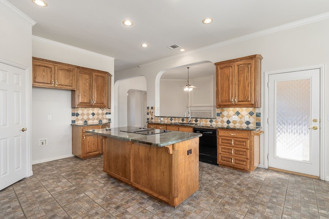 kitchen featuring tasteful backsplash, sink, a center island, and black appliances