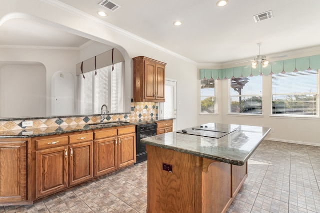 kitchen with a wealth of natural light, sink, a center island, decorative backsplash, and black appliances