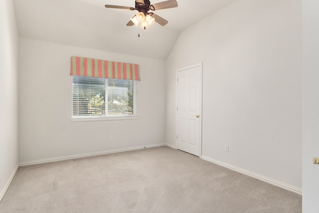 empty room featuring light carpet, vaulted ceiling, and ceiling fan