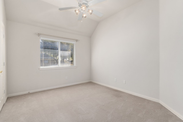 carpeted spare room with ceiling fan and lofted ceiling