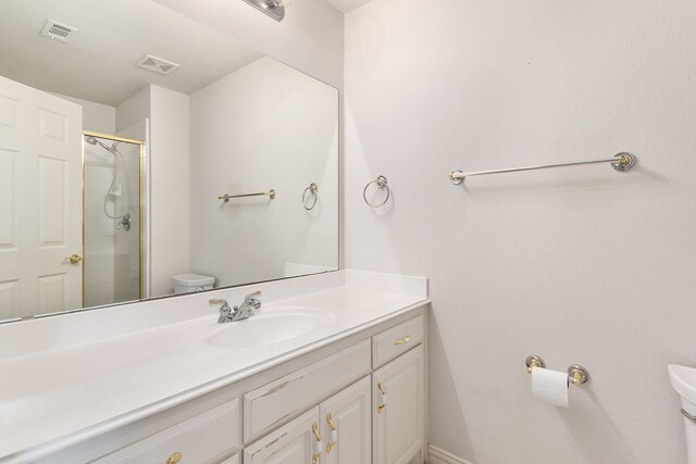 bathroom with vanity, an enclosed shower, and toilet