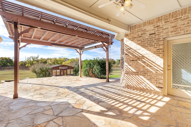 view of patio featuring a pergola, ceiling fan, and a storage unit