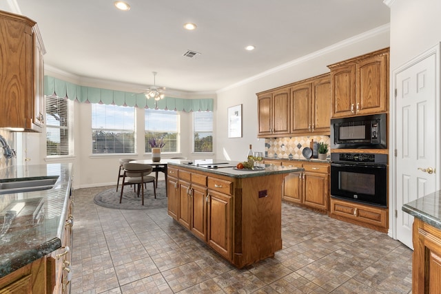 kitchen featuring backsplash, crown molding, sink, black appliances, and a center island