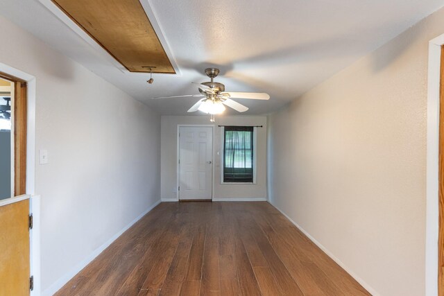 interior space featuring dark wood-style floors, ceiling fan, and baseboards