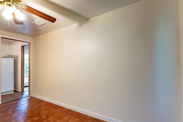 spare room featuring a ceiling fan, visible vents, and baseboards