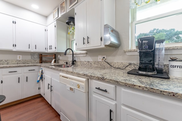 kitchen featuring dishwasher, white cabinets, sink, light stone counters, and dark hardwood / wood-style flooring