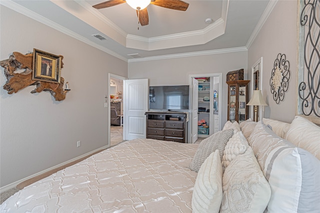 bedroom with a raised ceiling, ceiling fan, ornamental molding, carpet floors, and a closet