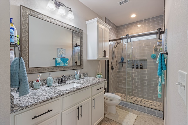 bathroom featuring vanity, toilet, and a shower with door