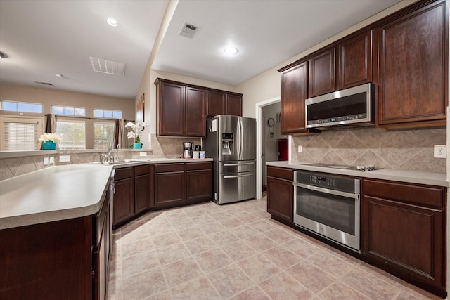 kitchen featuring backsplash, sink, dark brown cabinetry, and stainless steel appliances