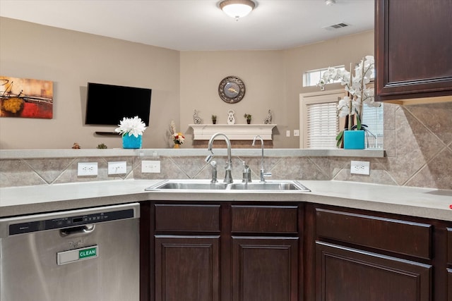 kitchen featuring dark brown cabinetry, backsplash, stainless steel dishwasher, and sink