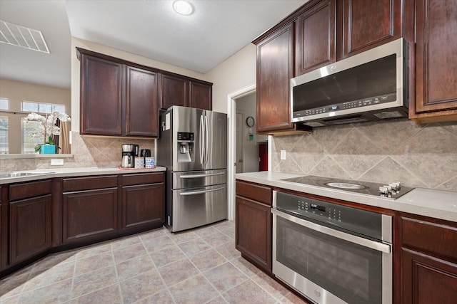 kitchen featuring appliances with stainless steel finishes, backsplash, dark brown cabinetry, and sink