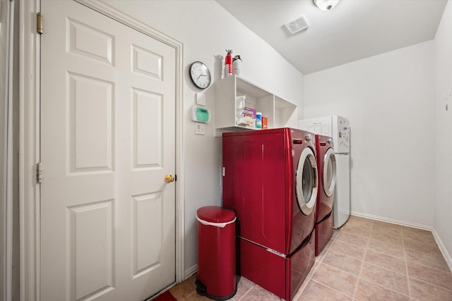 laundry area featuring light tile patterned floors and washer and dryer