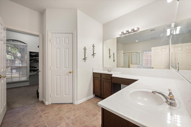 bathroom featuring tile patterned flooring, vanity, and an enclosed shower