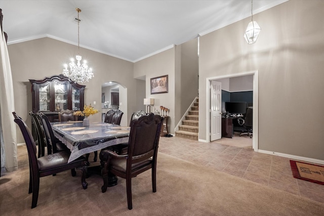 carpeted dining room with high vaulted ceiling, a chandelier, and ornamental molding