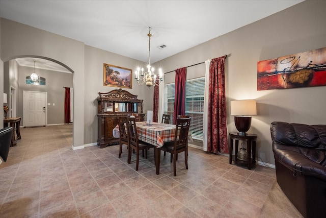 dining room with tile patterned flooring and a notable chandelier