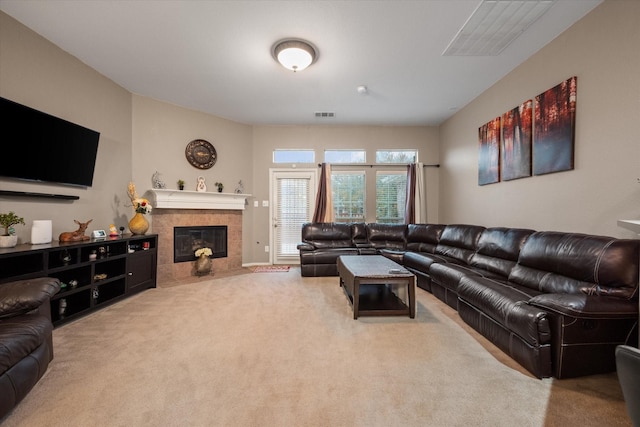 carpeted living room with a tiled fireplace