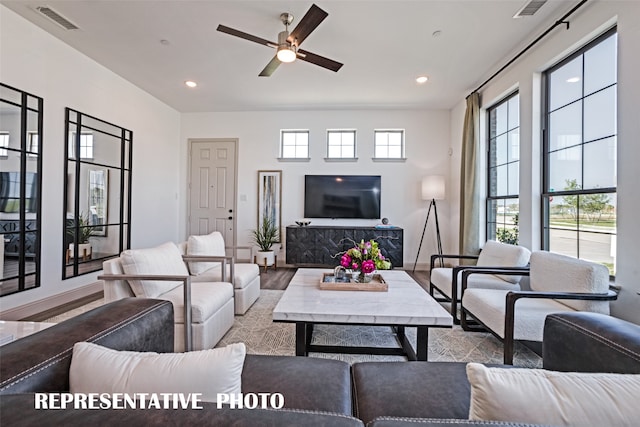 living room with light wood-type flooring, plenty of natural light, and ceiling fan